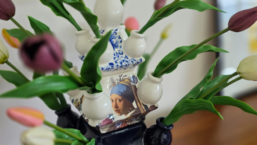Decorative vase with flowers on a wooden surface