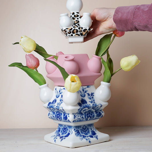 Decorative ceramic vase with floral design and leopard print accents on a beige background
