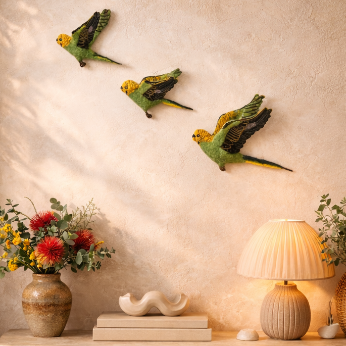 Two views of a decorative setup with birds on the wall and a table with flowers and books.