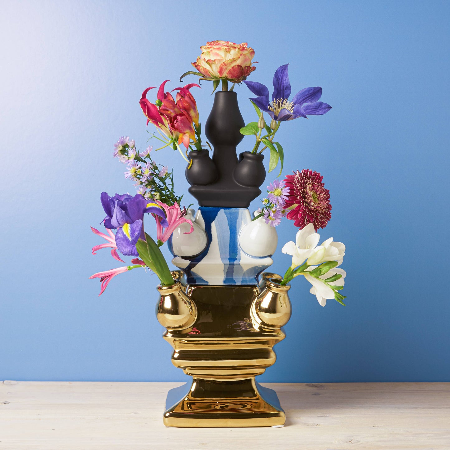 Decorative vase with colorful flowers against a blue background